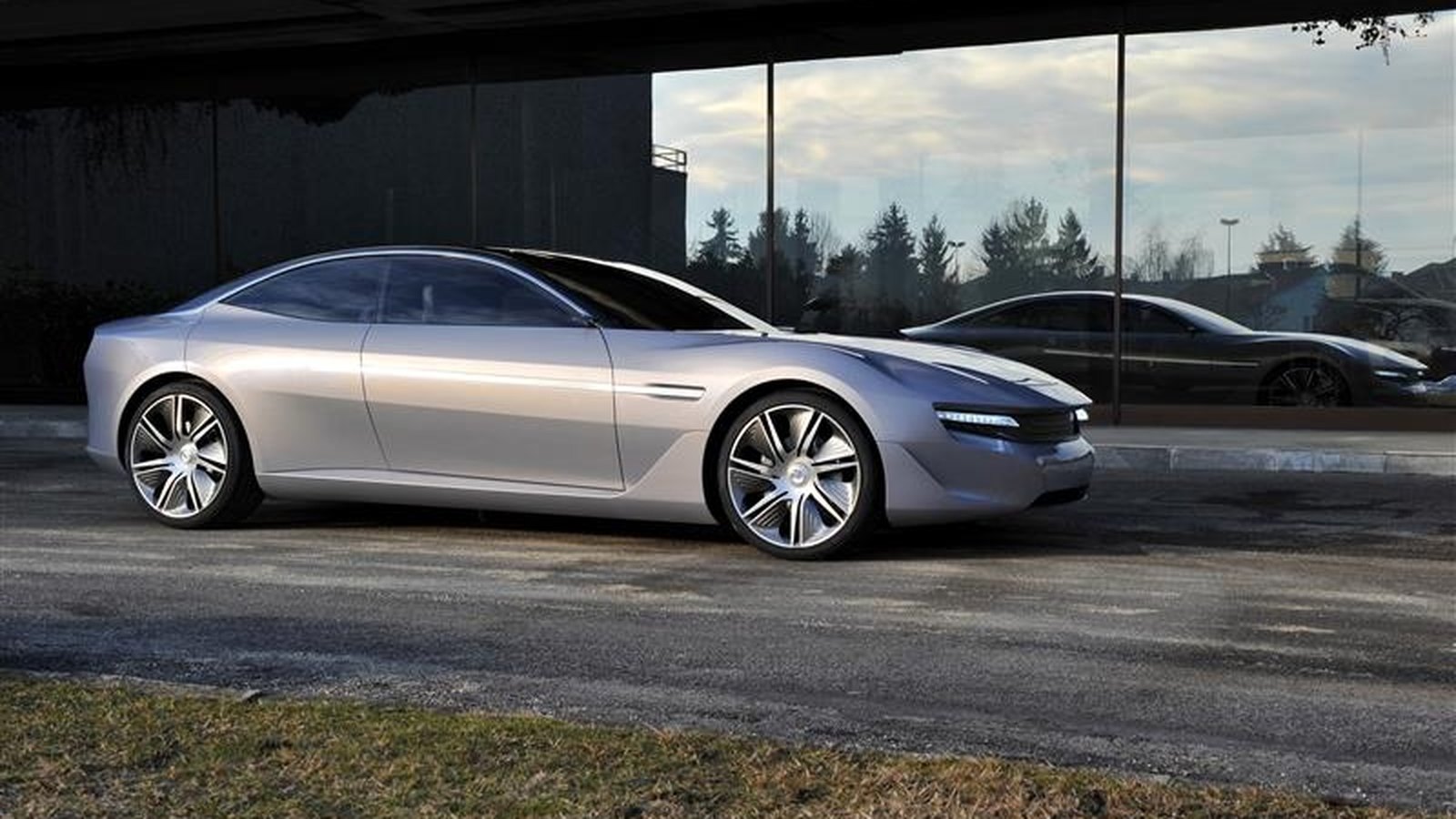 Pininfarina Cambiano concept car, a fluid silver grand tourer parked beside a glass facade