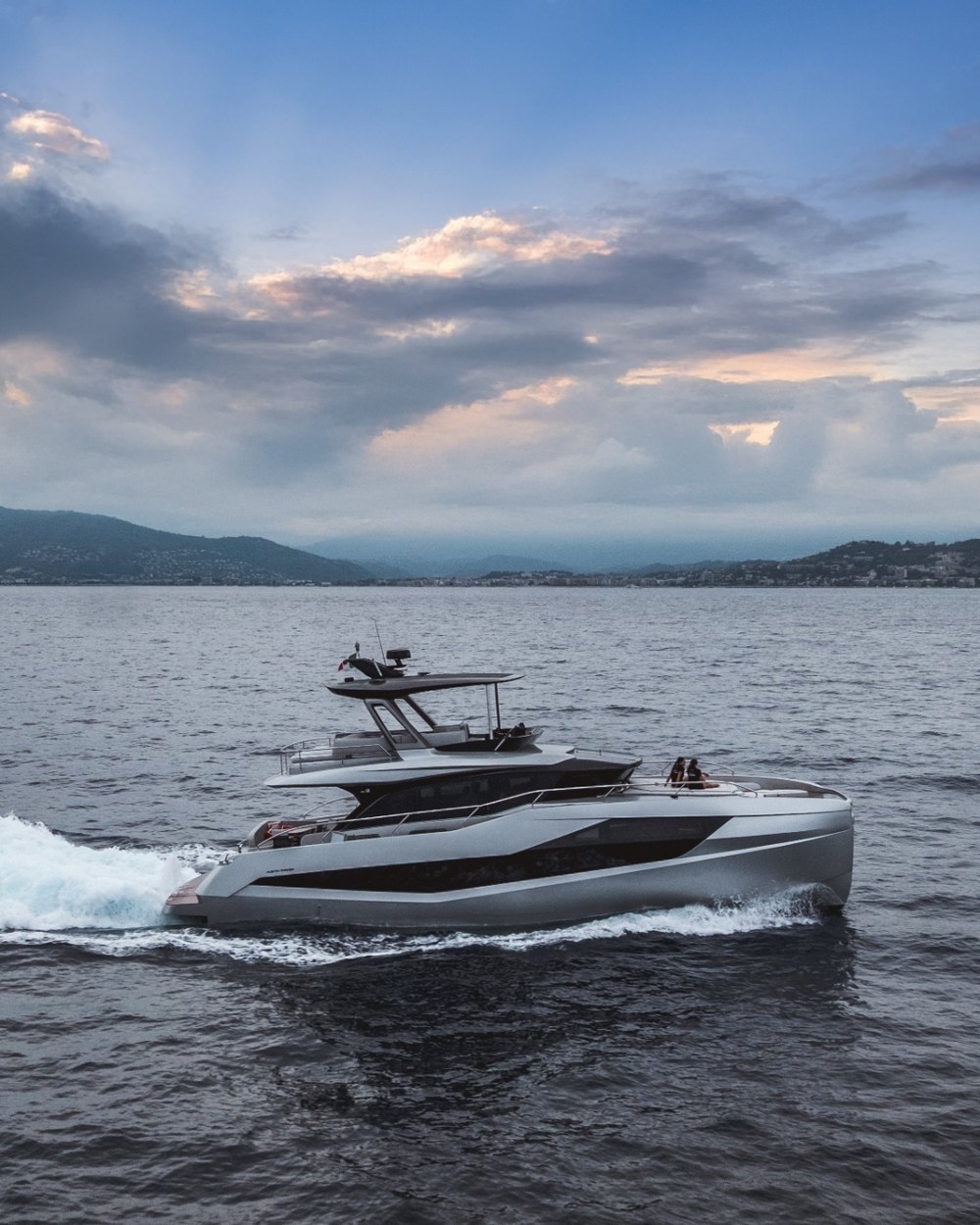 A sleek Pininfarina-designed motor yacht cruising off Cannes at dusk