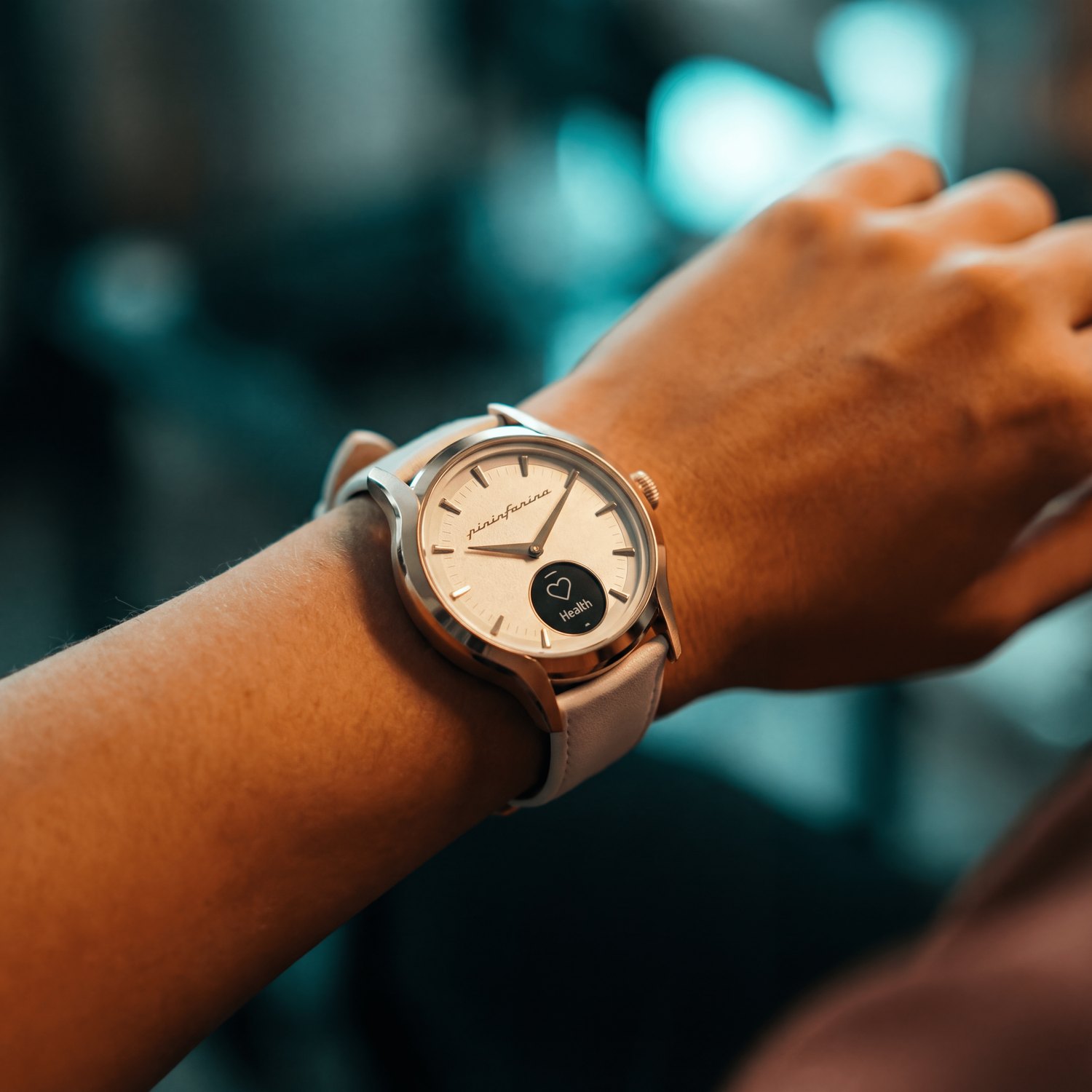 Pininfarina Pura hybrid smartwatch in rose gold worn on the wrist, warm cinematic lighting