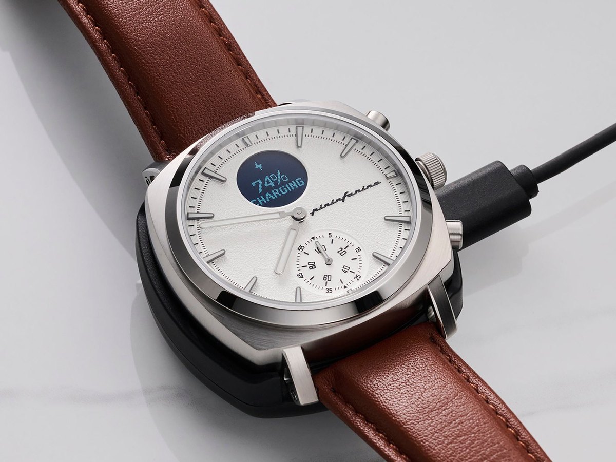 Hybrid watch resting on a charging cable showing 74 percent charging